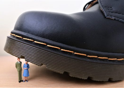 Man and woman crushed by a huge shoe