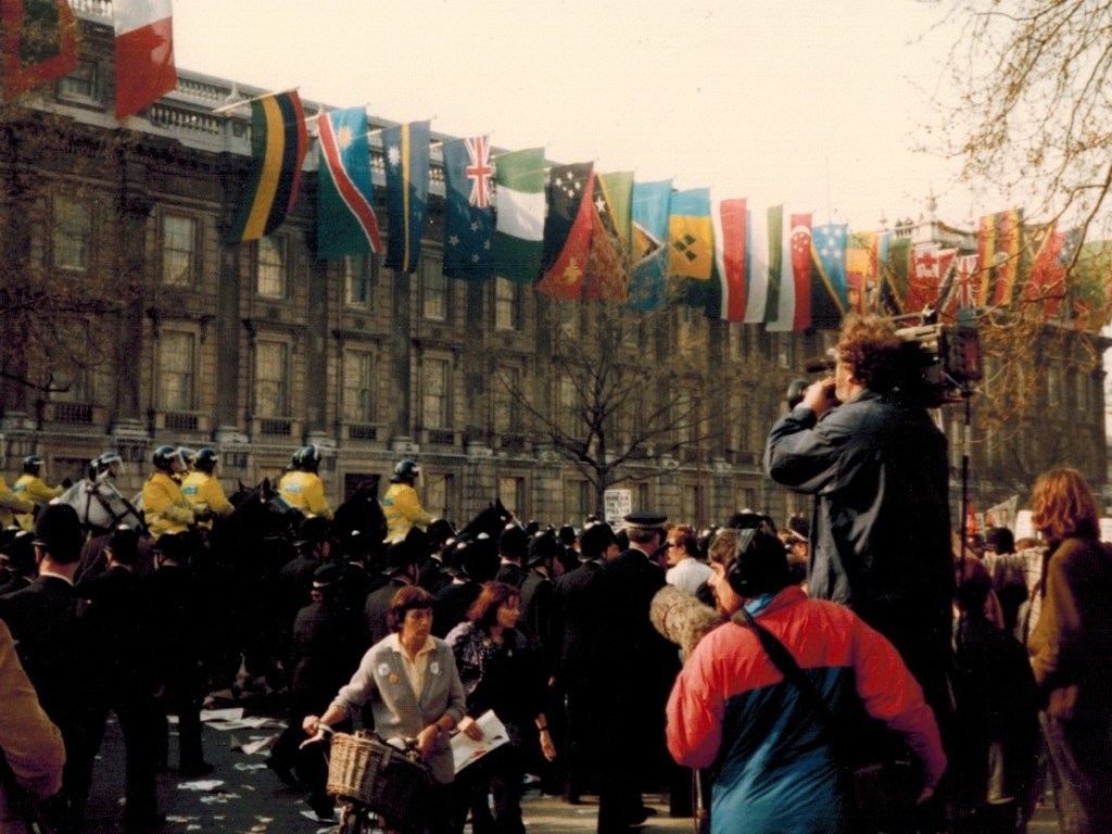 Whitehall flags, demonstrators, police and police horses.